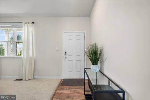 a view of a hallway with wooden floor and a potted plant