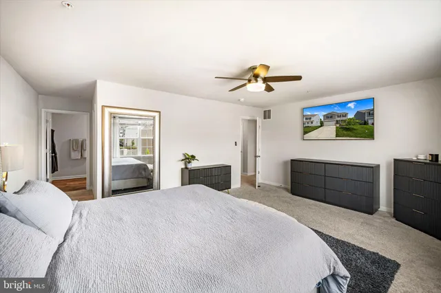 a bedroom with a large bed and a chandelier