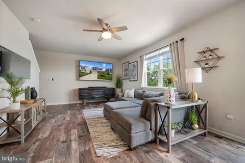 a living room with furniture and a wooden floor