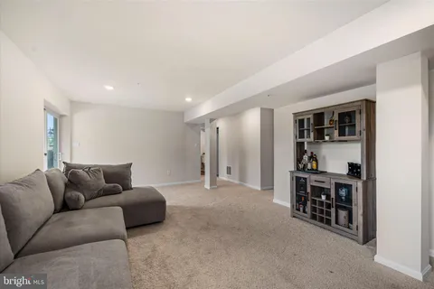 a living room with furniture and a book shelf