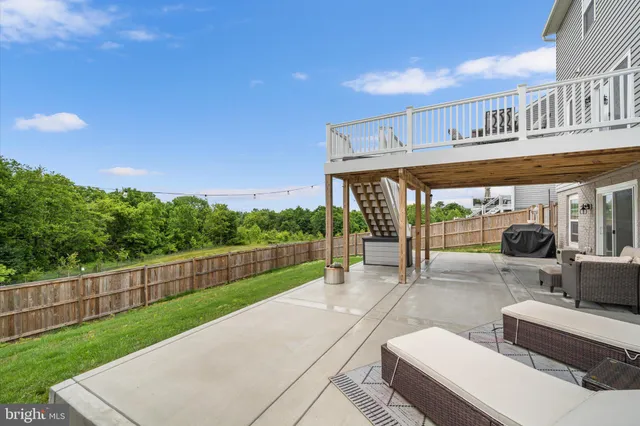 a view of a patio with a table and chairs under an umbrella with wooden fence