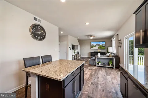 a living room with a table chairs and a stove with wooden floor