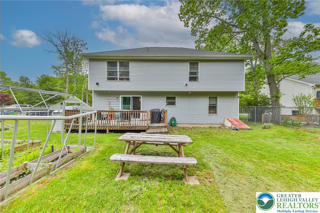 4608 Pine Ridge Drive West Bushkill, PA 18324 - Photo 51 of 62 A spacious backyard with a broad deck and thriving garden beds offers ample space for outdoor living.