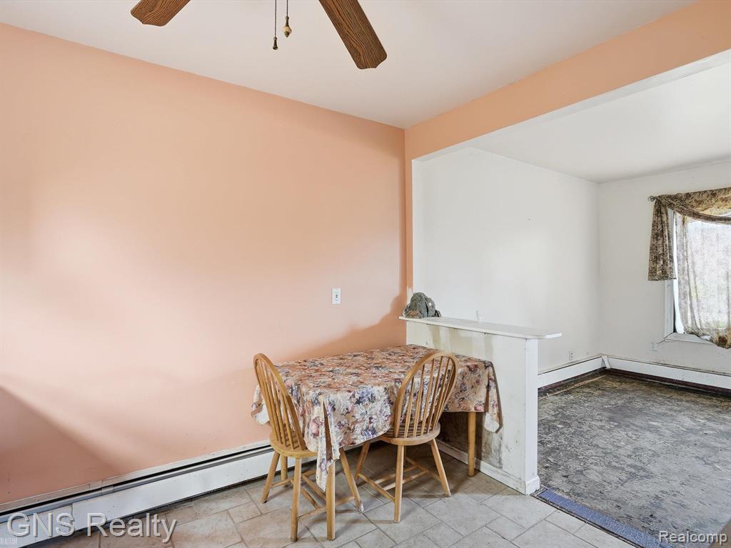 2717 Normandy Road Royal Oak, MI 48073 - Photo 9 of 13 Open concept dining area featuring a ceiling fan with light fixture, tiled flooring, baseboard heating, and a partition wall