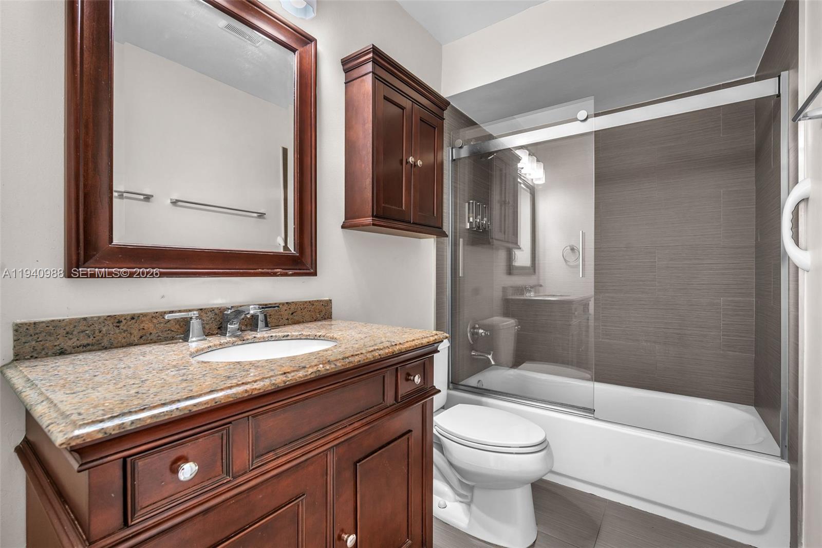 11125 Southwest 134th Court Miami, FL 33186 - Photo 21 of 33 a bathroom with a granite countertop sink a toilet a mirror and shower