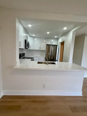 a view of kitchen with stainless steel appliances refrigerator sink and cabinets