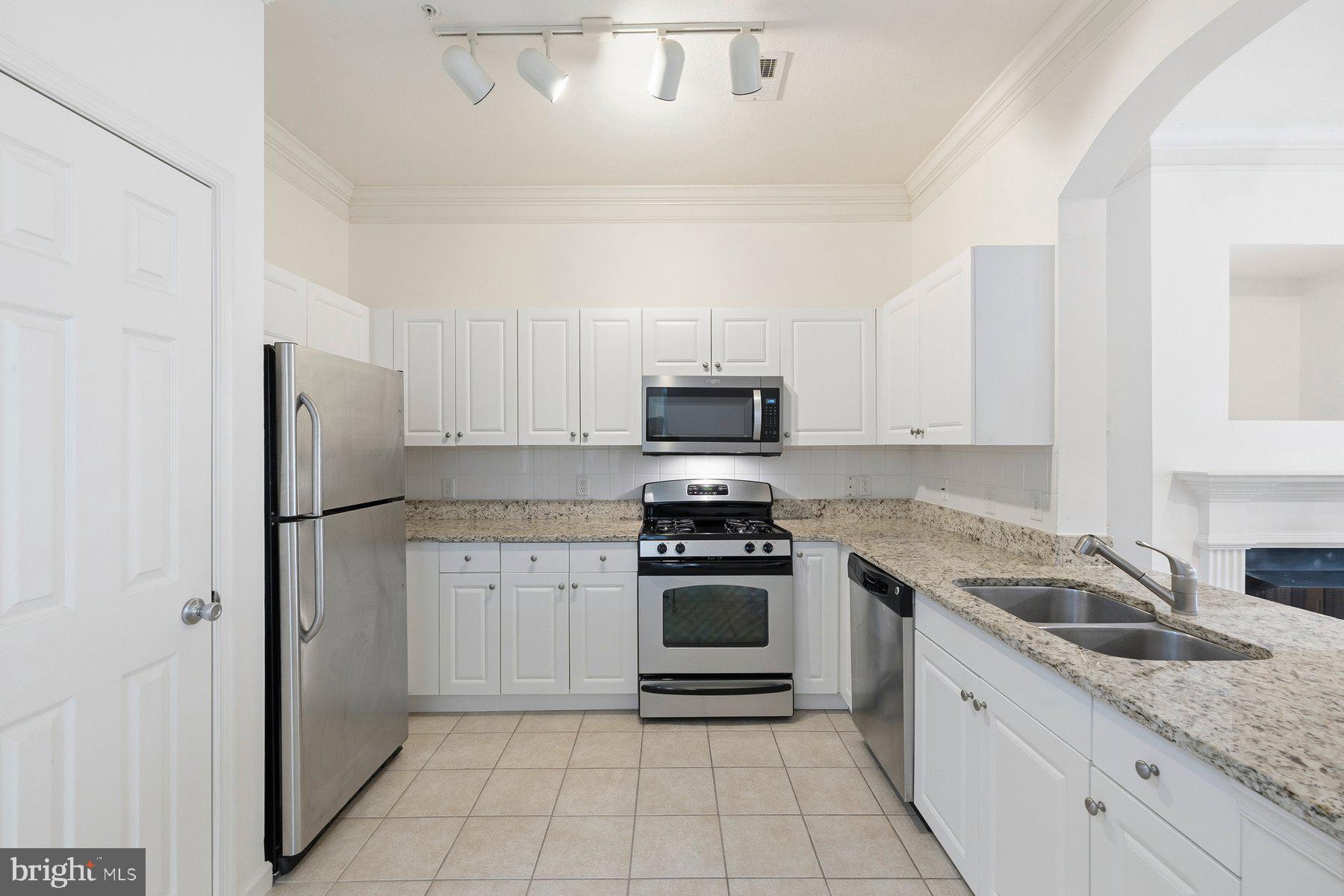 7 Booth Street, Unit 109 Gaithersburg, MD 20878 - Photo 11 of 28 a kitchen with granite countertop white cabinets and stainless steel appliances