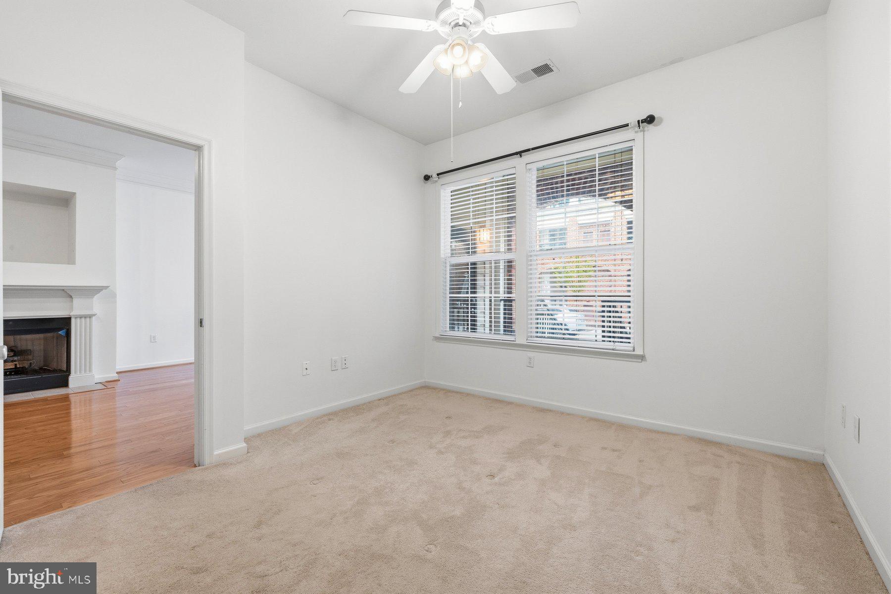 7 Booth Street, Unit 109 Gaithersburg, MD 20878 - Photo 15 of 28 an empty room with chandelier fan and windows