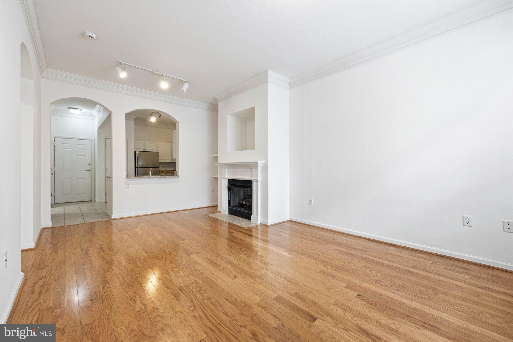 7 Booth Street, Unit 109 Gaithersburg, MD 20878 - Photo 3 of 28 a view of a livingroom with wooden floor and a fireplace