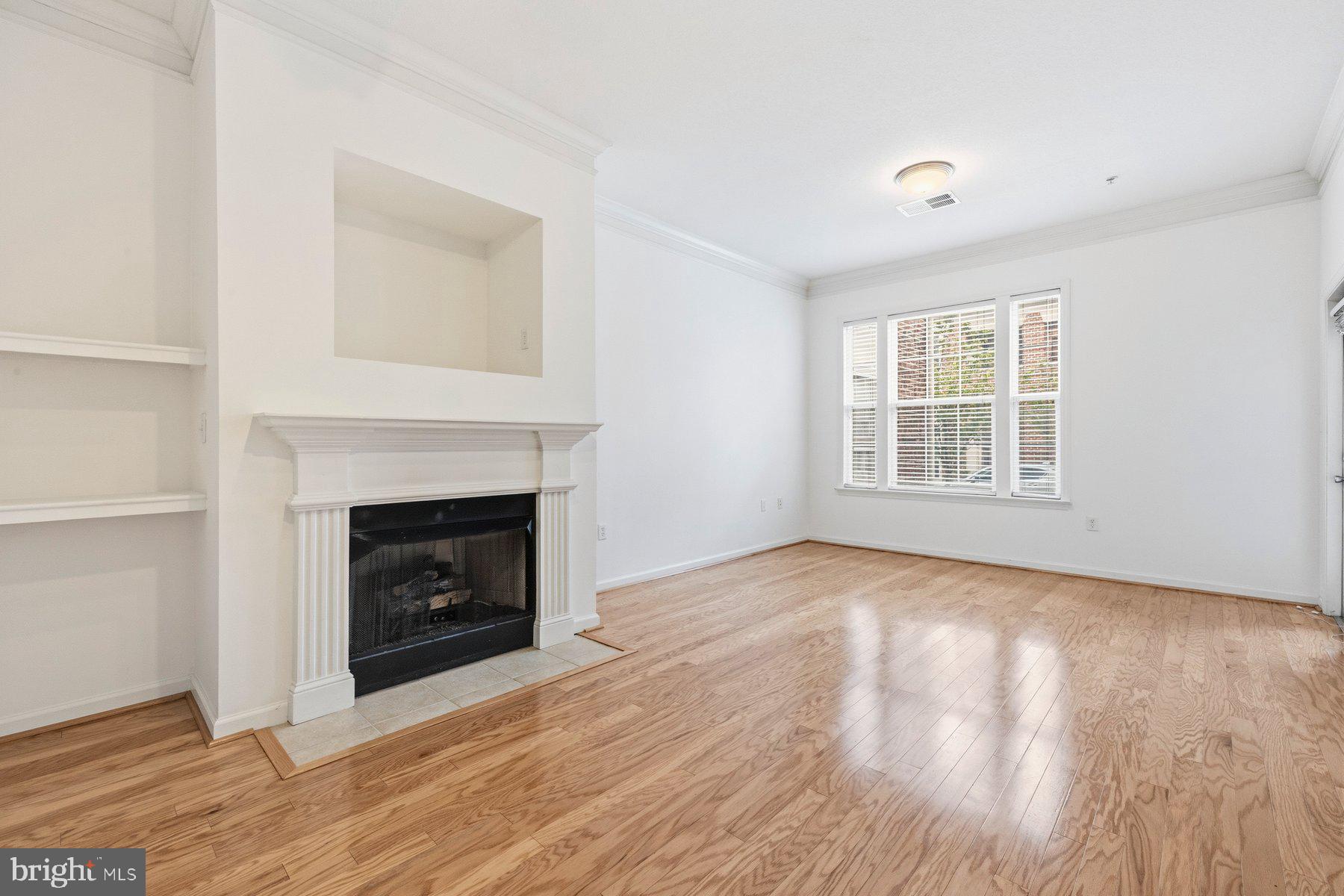 7 Booth Street, Unit 109 Gaithersburg, MD 20878 - Photo 5 of 28 an empty room with windows and a fireplace
