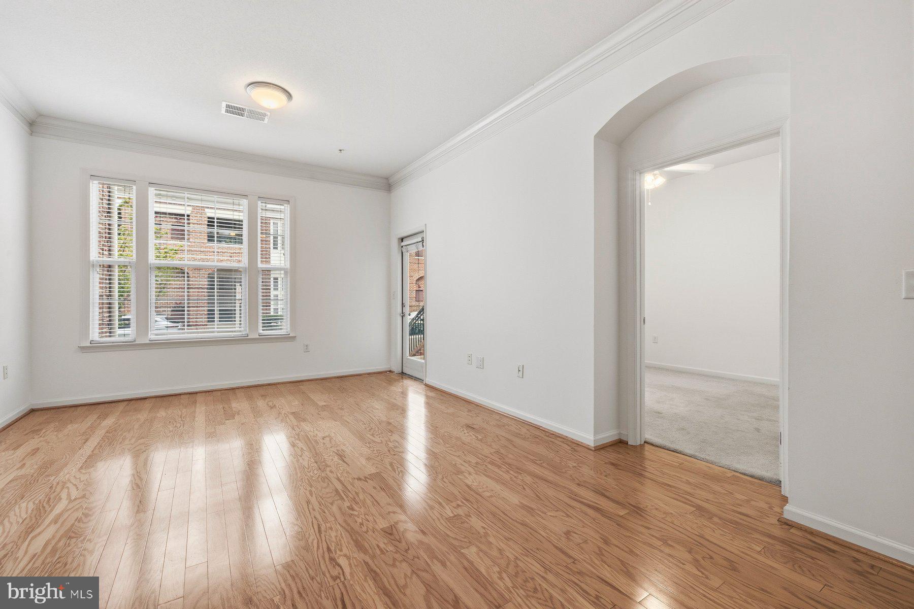 7 Booth Street, Unit 109 Gaithersburg, MD 20878 - Photo 6 of 28 an empty room with wooden floor and windows