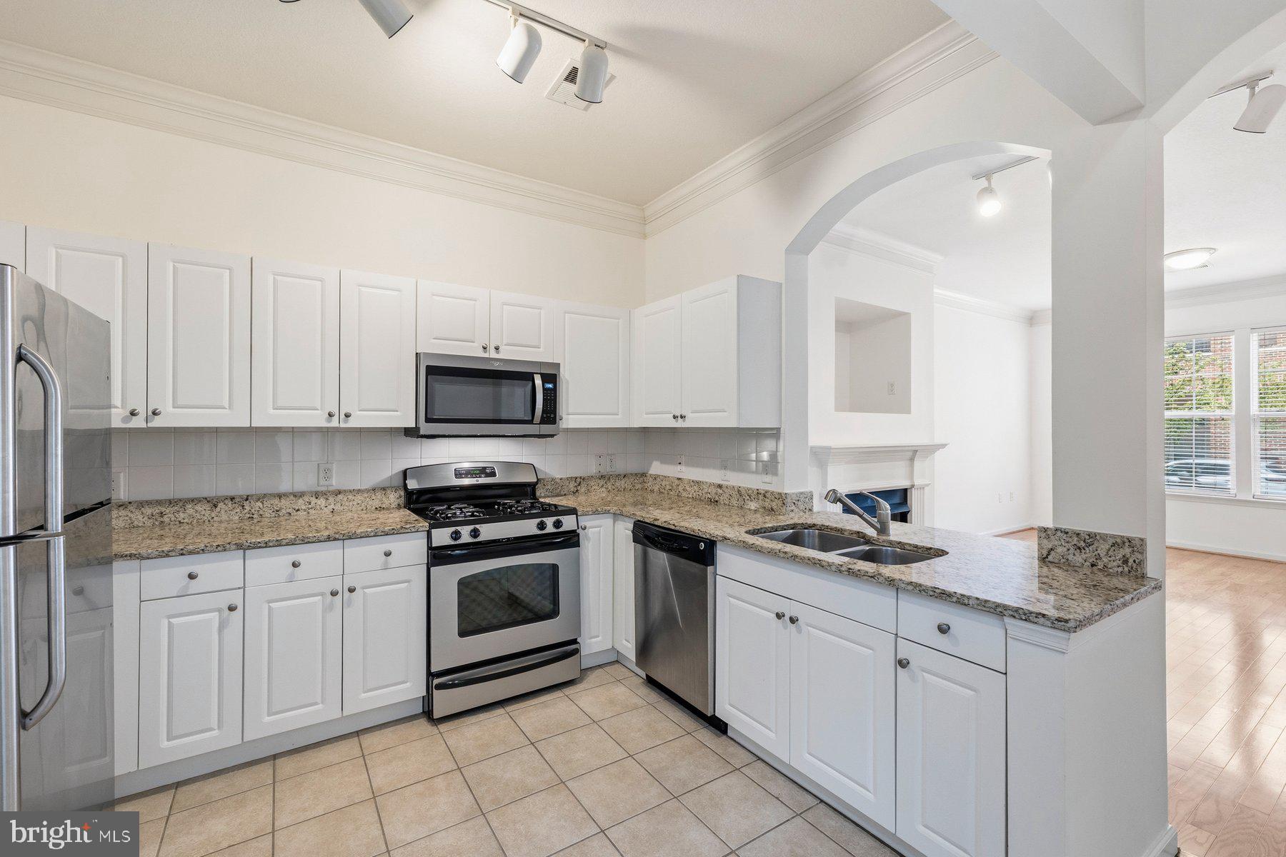 7 Booth Street, Unit 109 Gaithersburg, MD 20878 - Photo 8 of 28 a kitchen with granite countertop white cabinets and stainless steel appliances