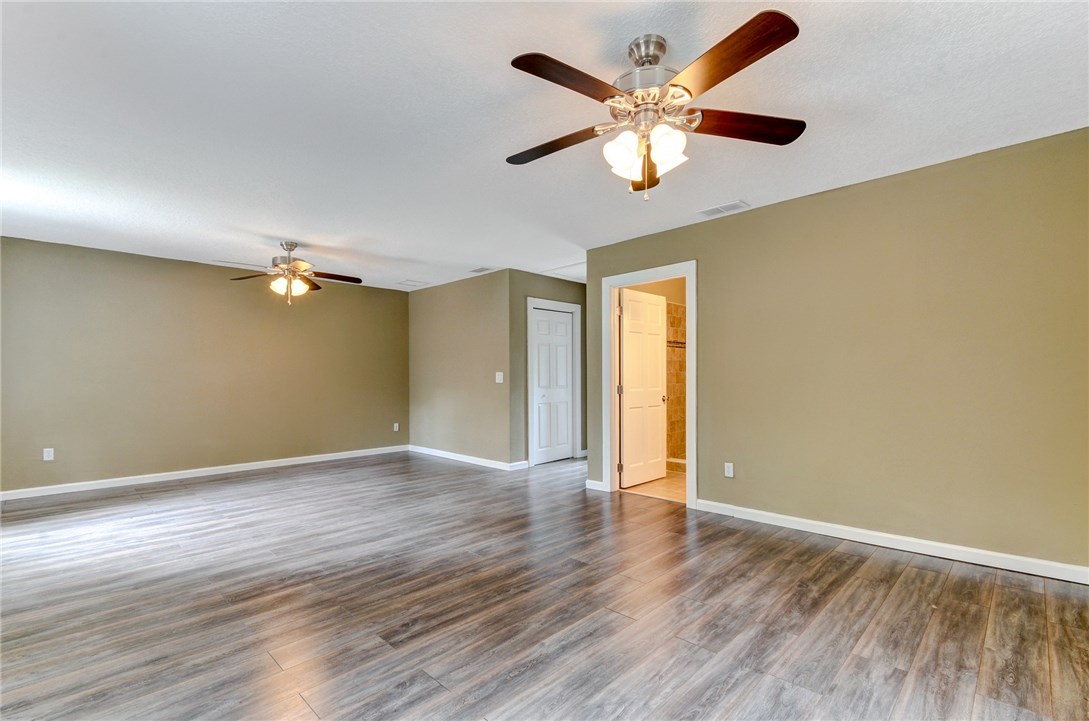 96231 Willyoung Road Yulee, FL 32097 - Photo 17 of 24 an empty room with wooden floor fan and windows