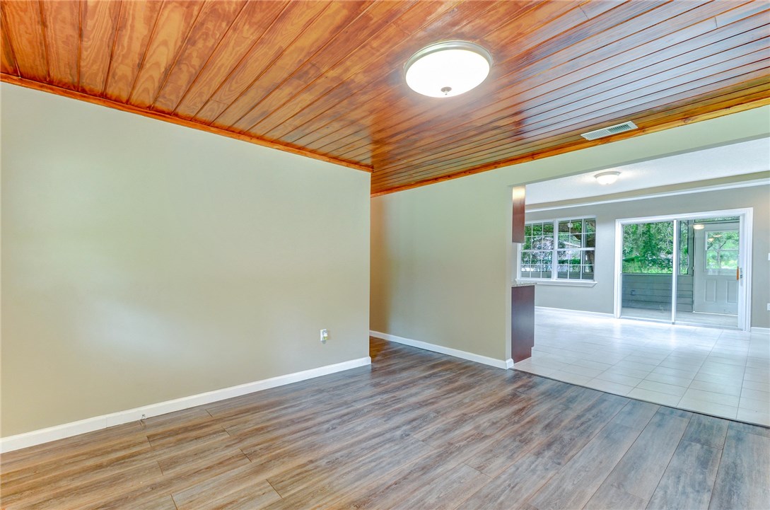 96231 Willyoung Road Yulee, FL 32097 - Photo 3 of 24 an empty room with wooden floor and windows