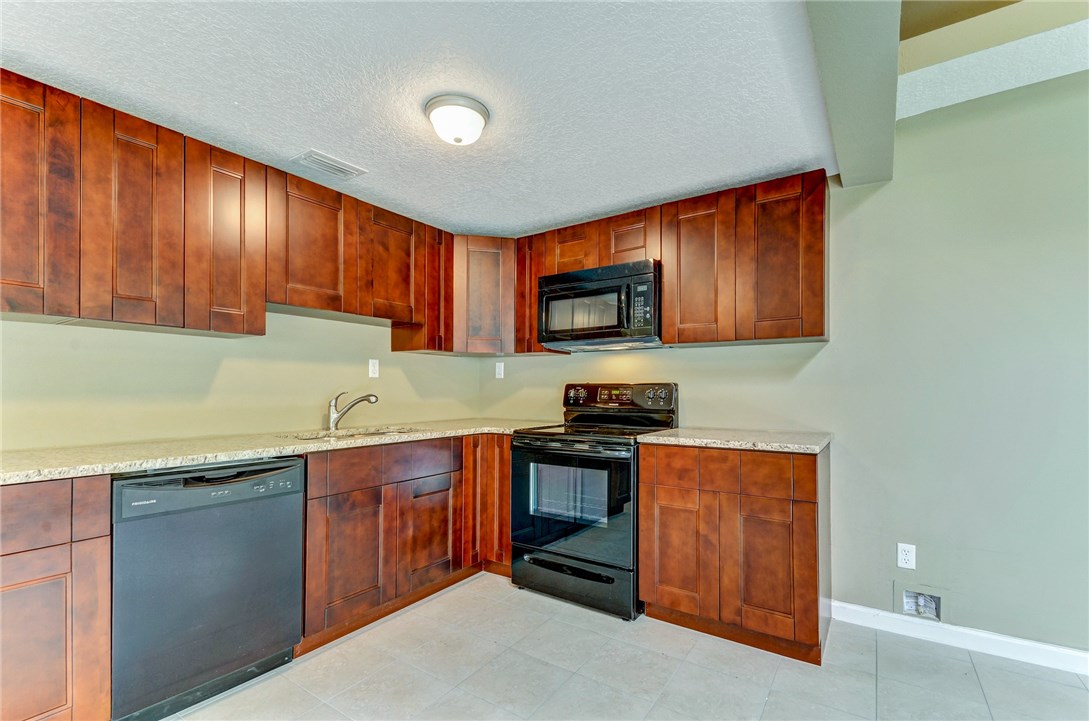 96231 Willyoung Road Yulee, FL 32097 - Photo 5 of 24 a kitchen with stainless steel appliances granite countertop wooden cabinets a stove top oven a sink and dishwasher