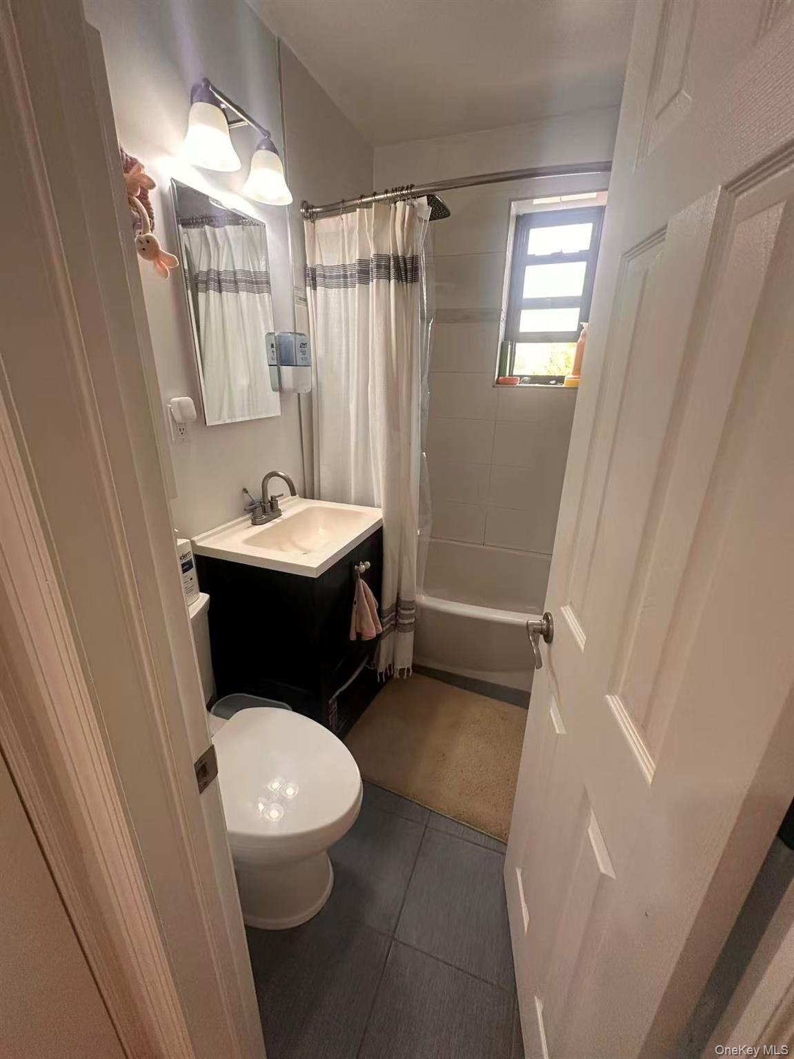 139-15 28th Road, Unit 6G Queens, NY 11354 - Photo 13 of 20 a bathroom with a sink a toilet a mirror and shower