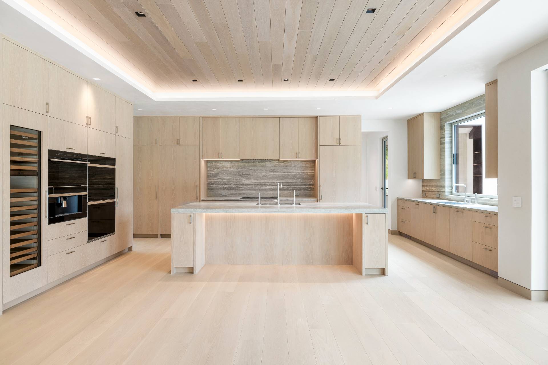 10 Mill Path Bridgehampton, NY 11963 - Photo 13 of 46 a large white kitchen with stainless steel appliances kitchen island granite countertop a stove and a sink with cabinets