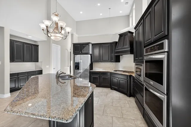 a kitchen with stainless steel appliances granite countertop a sink refrigerator and stove