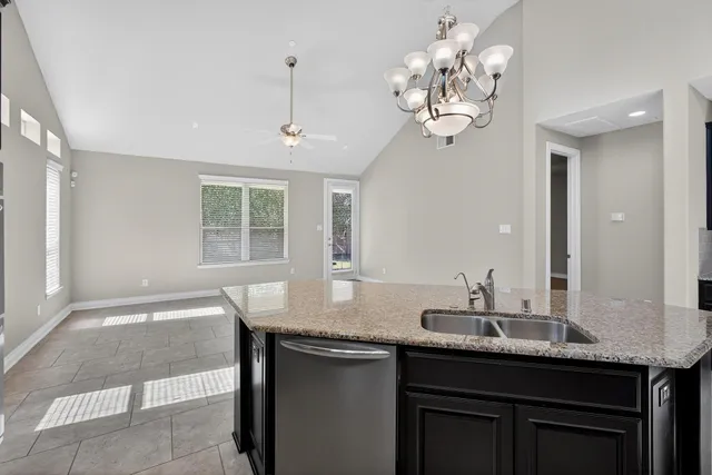 a bathroom with a granite countertop sink a large mirror and a window