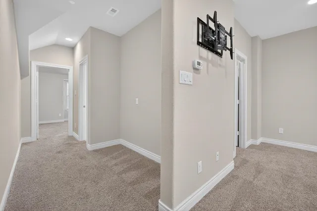 an empty room with a chandelier fan and windows