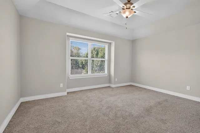 a view of an empty room with a ceiling fan