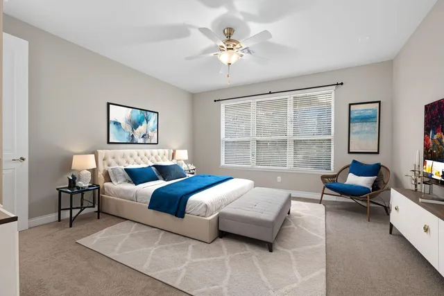 a bedroom with bed couch and window