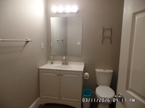 a bathroom with a toilet a sink and mirror