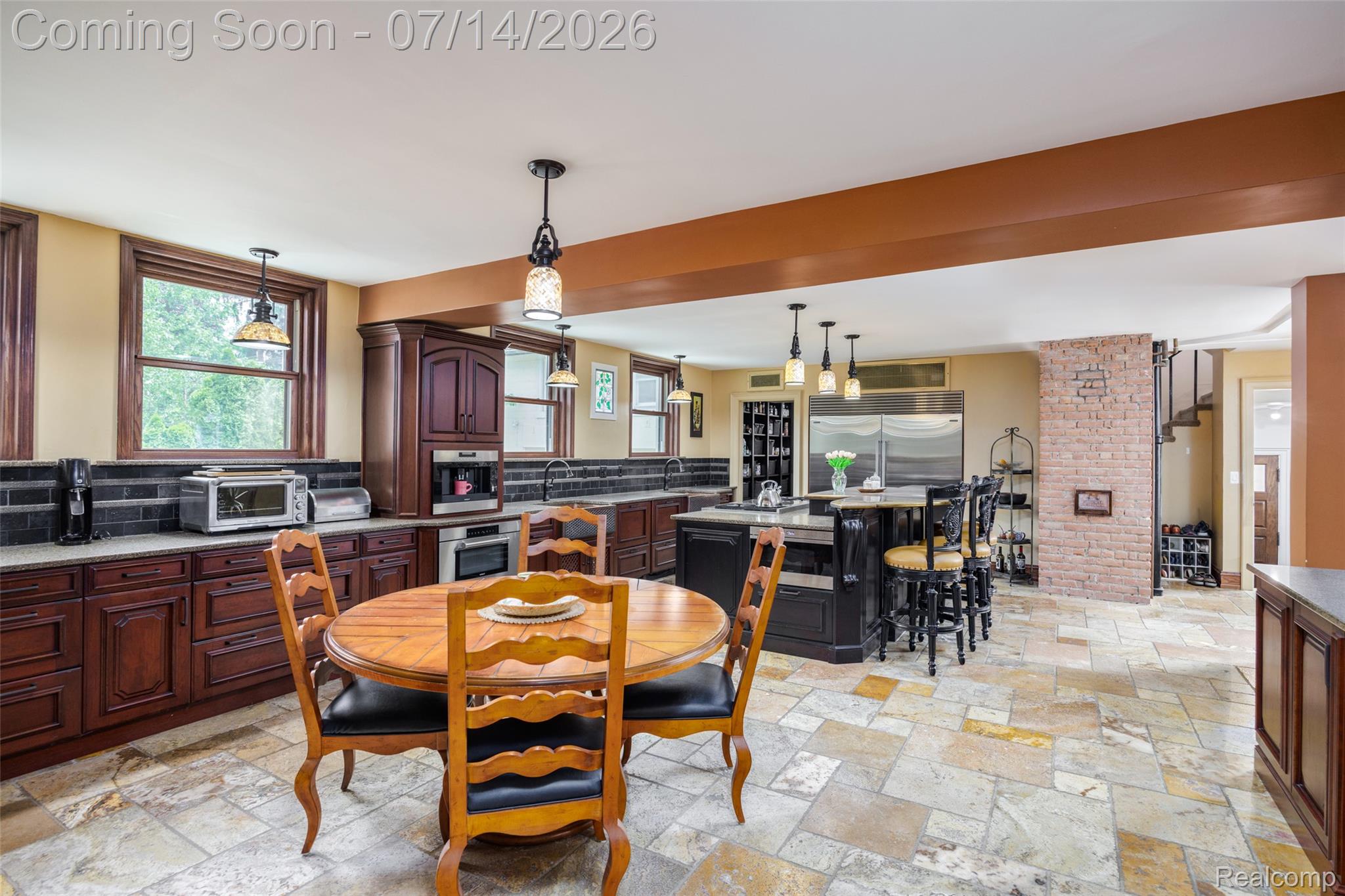 189 Cloverly Road Grosse Pointe, MI 48236 - Photo 21 of 96 Spacious kitchen featuring stone tile flooring, dark wood cabinetry, and a central island with bar seating