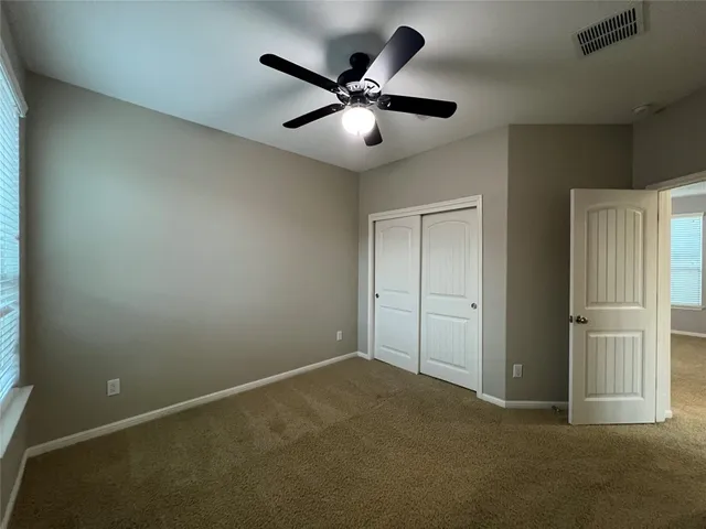 an empty room with closet and windows