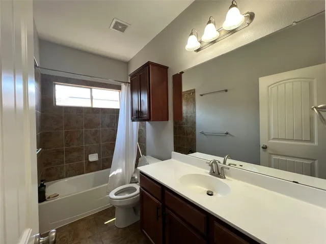 a bathroom with a double vanity sink toilet and shower