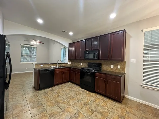 a kitchen with stainless steel appliances granite countertop a stove sink and cabinets
