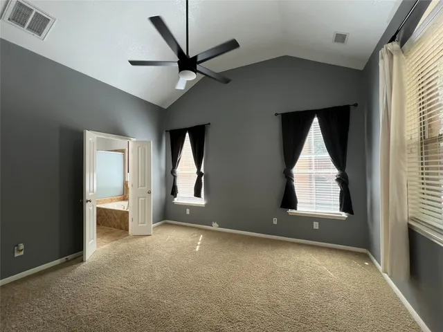 a view of an empty room with a window and a kitchen