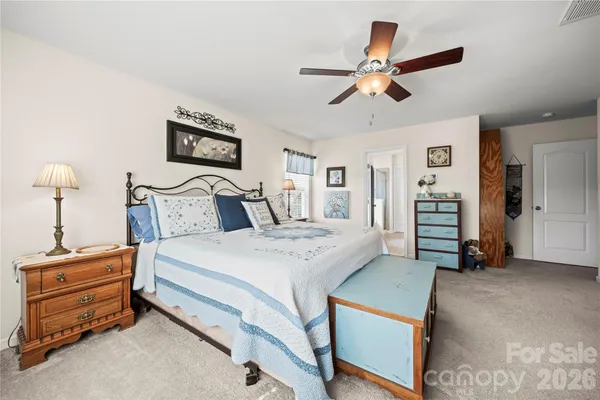 a bedroom with a bed and a ceiling fan