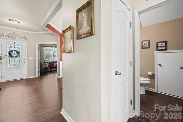 a view of a hallway with bathroom and wooden floor