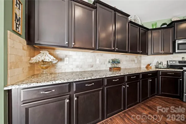 a kitchen with granite countertop stainless steel appliances wooden cabinets and a sink