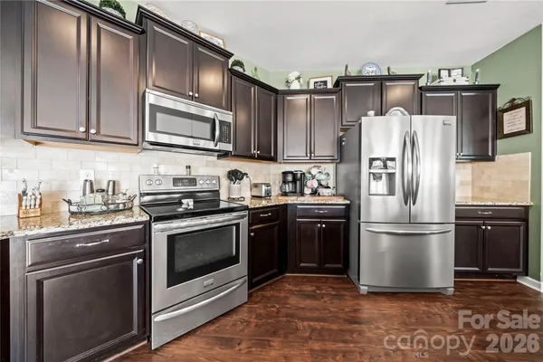 a kitchen with stainless steel appliances granite countertop a refrigerator stove and sink