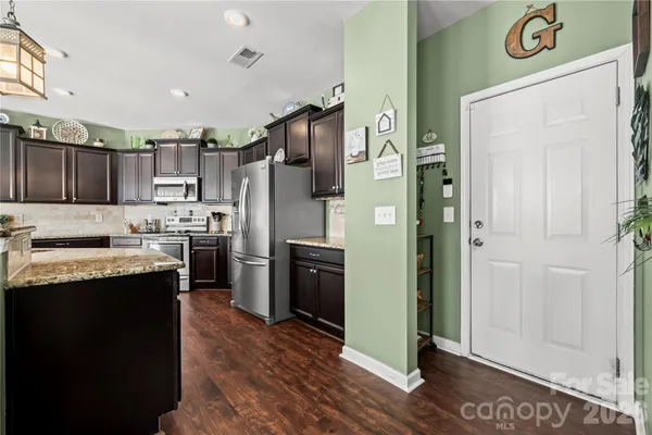 a kitchen with stainless steel appliances granite countertop a refrigerator a sink and a stove