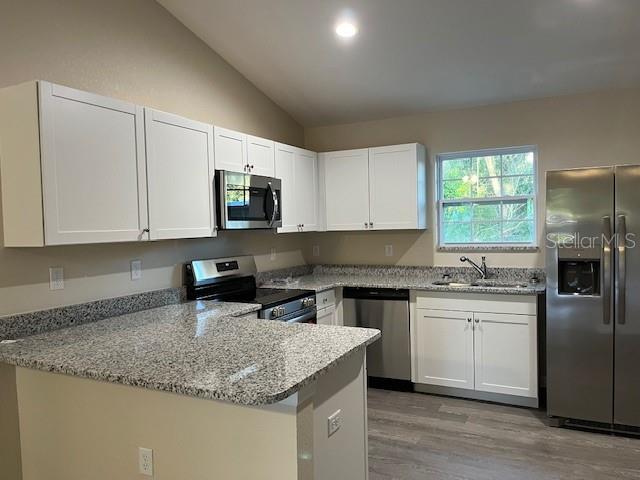 4366 Southeast 138th Street Summerfield, FL 34491 - Photo 4 of 23 a kitchen with granite countertop a sink stove top oven and refrigerator