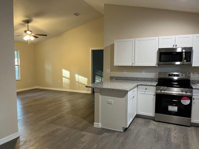 4366 Southeast 138th Street Summerfield, FL 34491 - Photo 7 of 23 a kitchen with granite countertop a stove a sink and a microwave