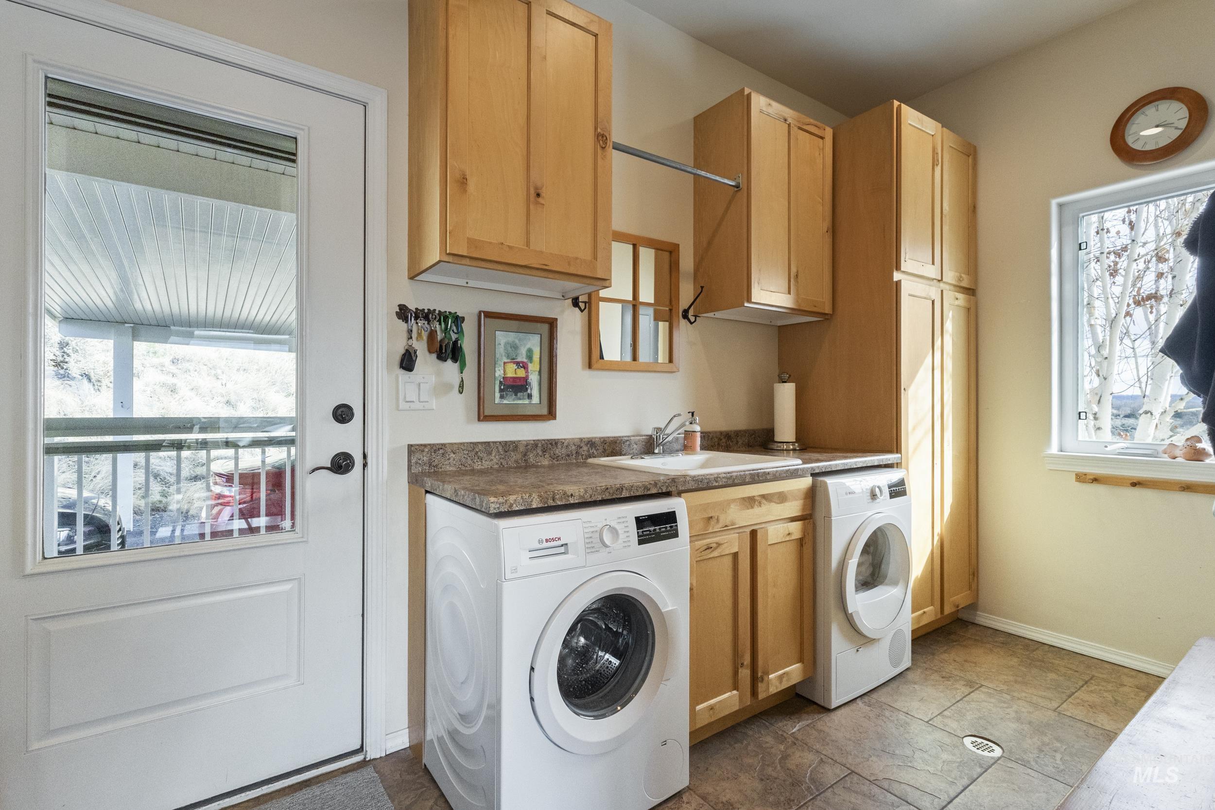 382 River Road Bliss, ID 83314 - Photo 28 of 46 Laundry area featuring cabinet space, healthy amount of natural light, and dark stone finish floors