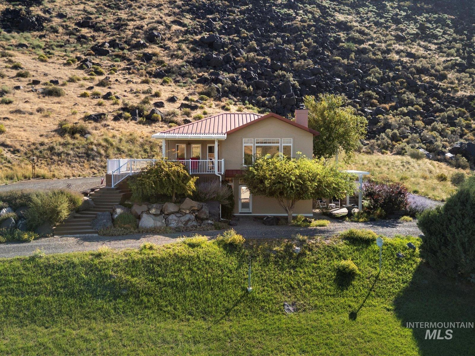 382 River Road Bliss, ID 83314 - Photo 30 of 46 View of front of property with stairs, stucco siding, a chimney, and a porch