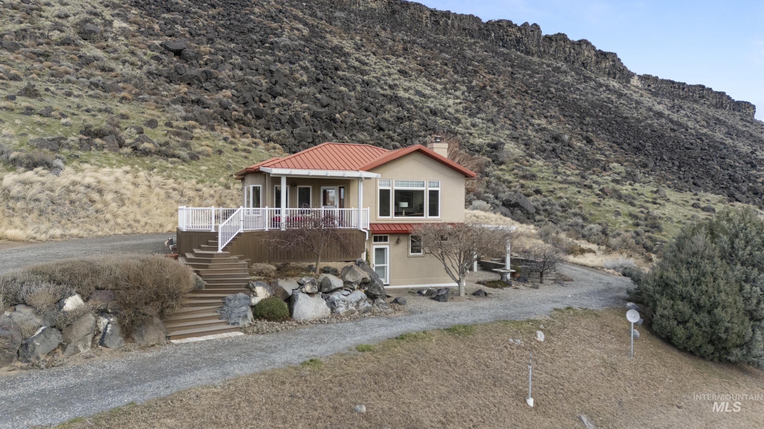382 River Road Bliss, ID 83314 - Photo 31 of 46 View of front facade with stucco siding, a chimney, a mountain view, and a metal roof