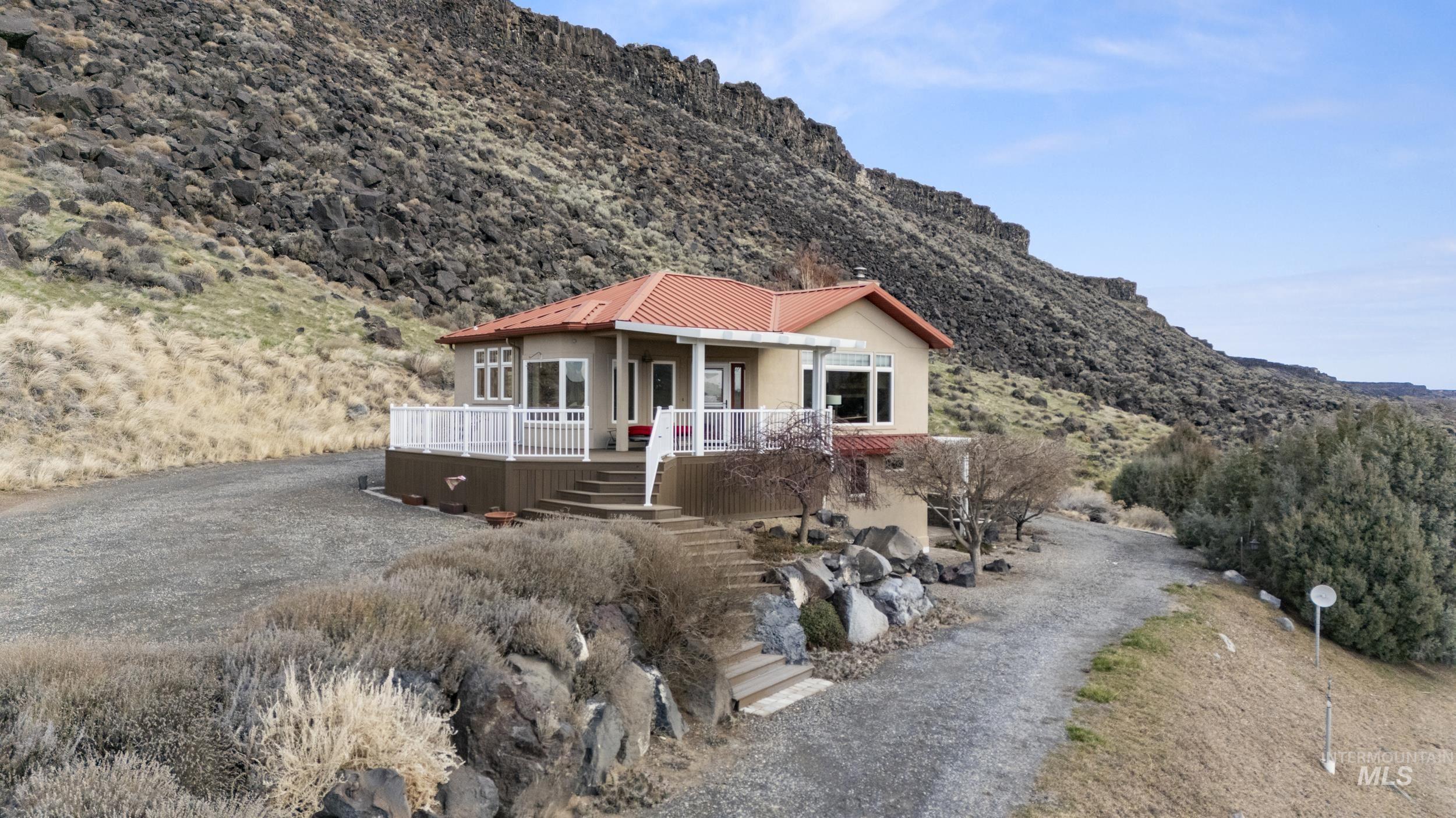 382 River Road Bliss, ID 83314 - Photo 41 of 46 View of front facade featuring a mountain view, driveway, a metal roof, and stucco siding