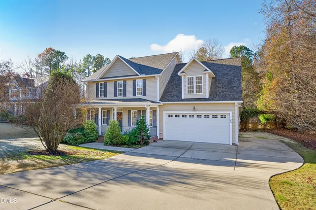 a front view of a house with a yard and trees