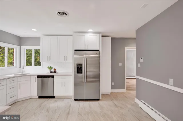 a kitchen with white cabinets and white appliances