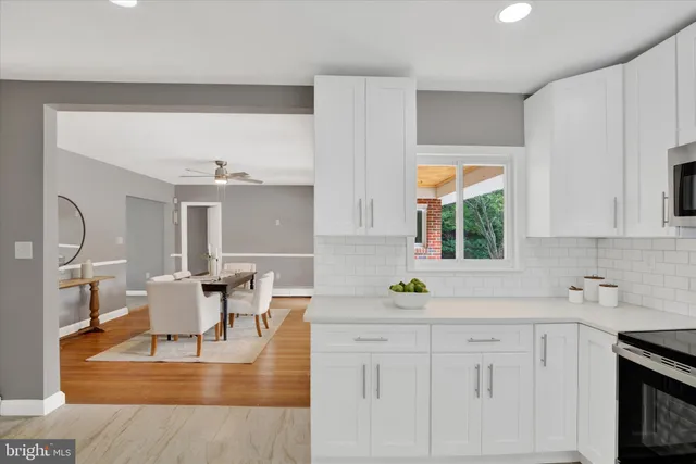 a kitchen with stainless steel appliances a sink a refrigerator and window
