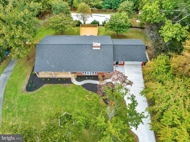 an aerial view of residential houses with outdoor space and trees