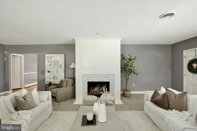 a living room with furniture large window and fireplace