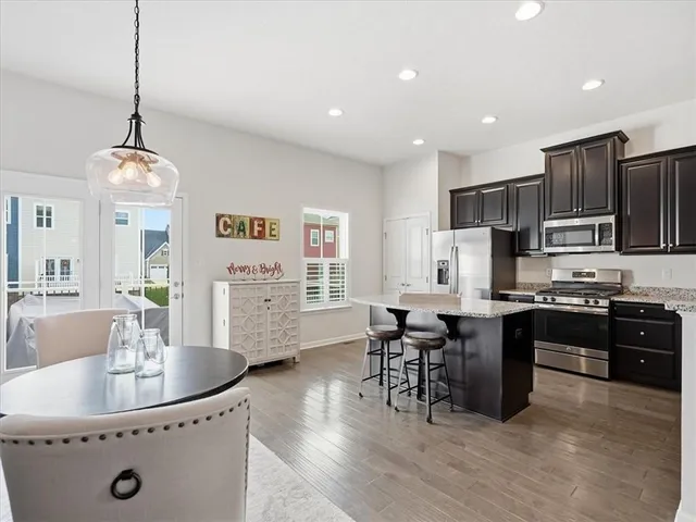a kitchen with stainless steel appliances granite countertop a sink refrigerator and cabinets