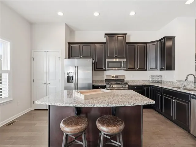 a kitchen with stainless steel appliances granite countertop a sink stove and microwave